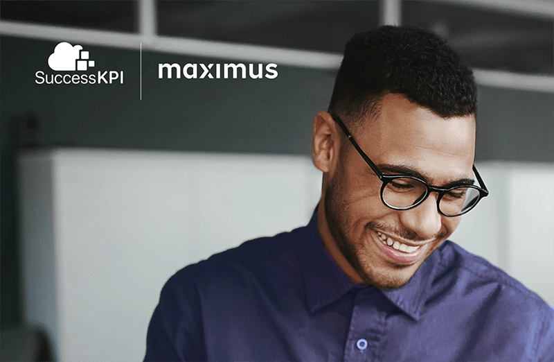 A smiling person wearing glasses and a blue shirt is in an office, with 